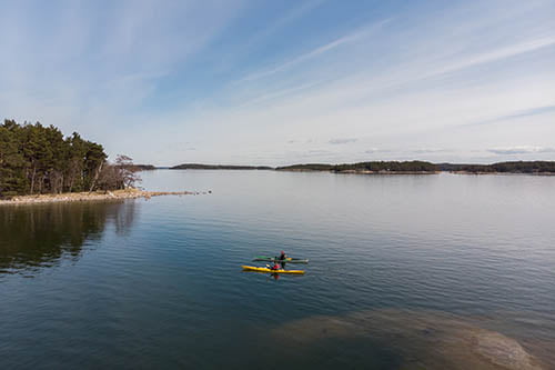 Drone perspective of two persons kayaking on the archipelago sea