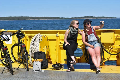 Two girls taking a selfie on a yellow ferry in the archipelago
